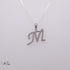 Silver necklace with 'M' pendant on a light gray background